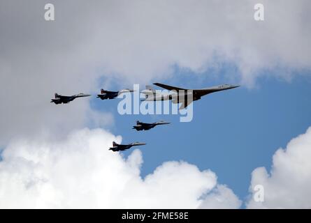 MOSCOW, RUSSIA - May 7, 2021: Russian military Supersonic bomber-missile carrier TU-160 White Swan and four SU-35S fighters following on the sides Stock Photo