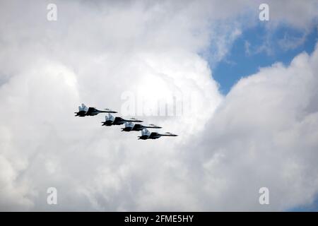 MOSCOW, RUSSIA - MAY 7, 2021: Group of four Russian military supersonic high-altitude interceptors SU-35 in flight on parade rehearsal in cloudy sky Stock Photo