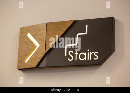 Closeup shot of a horizontal wooden guiding sign leading to the stair Stock Photo