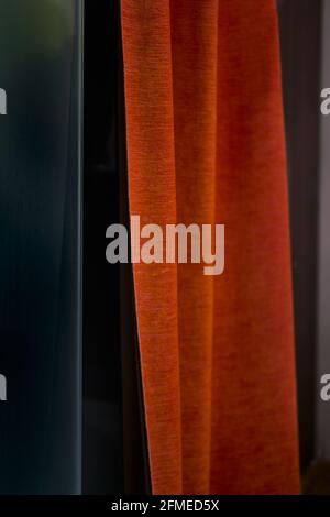 detail of textured orange fabric drape against neutral background Stock Photo