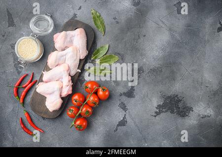 Uncooked chicken wings with spices, and sesame, on wooden cutting board, on gray background, top view flat lay, with copy space for text Stock Photo