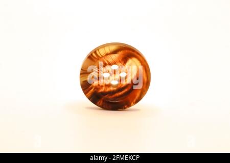 A macro photo of a striped four hole clothes button isolated against a white background Stock Photo