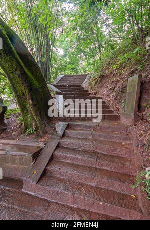 Fengdu, China - May 8, 2010: Ghost City, historic sanctuary. Crooked brown stone stairway in green park. Stock Photo