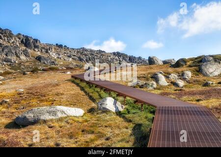 Walking boarwalk up to the summit of Mt Kosciuszko in Snowy Mountains national park of Australia - sunny autumn day. Stock Photo