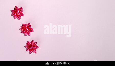 Red gift bow on pink background template for posters and banners Stock Photo