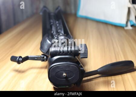 black colored tripod on wooden table for photograph Stock Photo