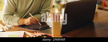 Cropped shot of a man drawing illustration on his graphic tablet. Artist using digital tablet to draw illustrations at home. Stock Photo