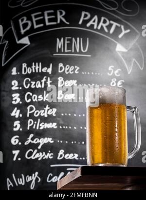 Full Glass Of The Cold Beer With Foam On A Wooden Table At Background Of A  Chalk Board With Menu Text, Bottom-Up View. Draft Beer On A Bar Counter In  Stock Photo -