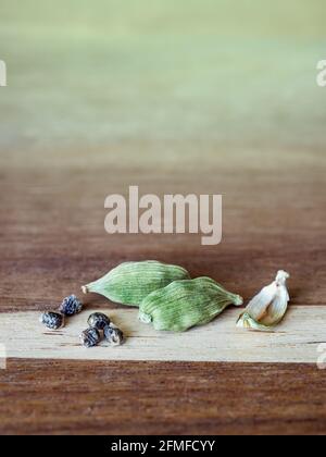 Pods of cardamom with seeds on a wooden table, close-up. Stock Photo