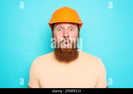 Incompetent worker is unsure about his work and has doubts. cyan background Stock Photo