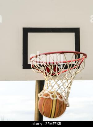 Basketball going through hoop Stock Photo