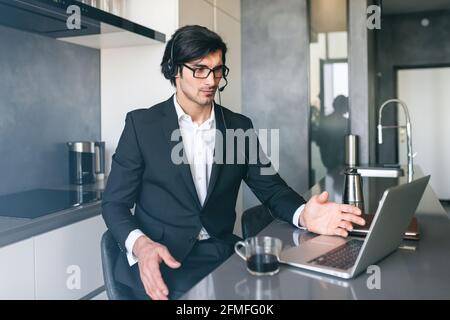 Businessman with headset at a video conference from his home computer Stock Photo
