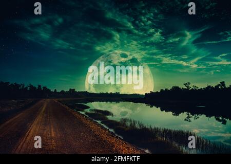 Photo Manipulation. Beautiful night sky with many stars. Landscape of green sky with super moon above silhouettes of trees. Serenity nature background Stock Photo