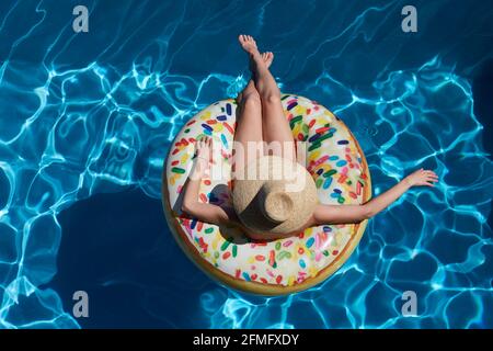 Young woman on inflatable donut ring in pool Stock Photo