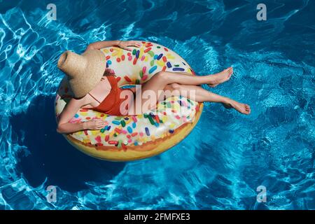 Young woman on inflatable donut ring in pool Stock Photo