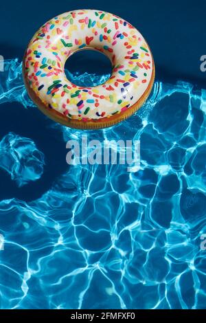 Inflatable donut ring in blue swimming pool Stock Photo