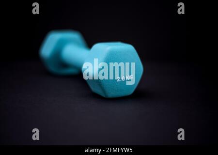 2 kg dumbbells isolated on dark background - home fitness and workout. Stock Photo