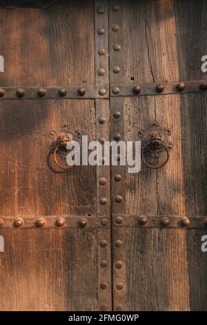 Retro lion head iron door knocker on ancient Chinese wooden door Stock Photo