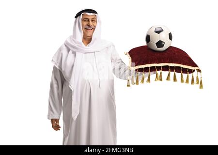 Mature arab man holding a football on a red velvet cushion isolated on white background Stock Photo