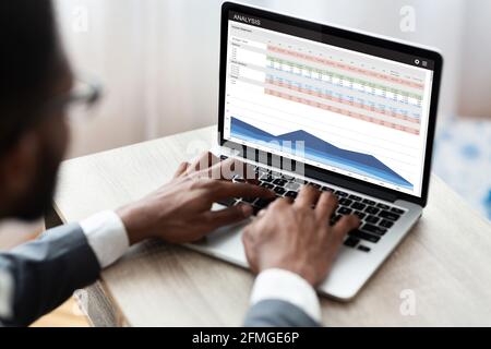 Business analyst researching market, using laptop in office Stock Photo