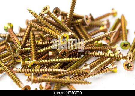yellow self-tapping screw on a white background. A large number of screws Stock Photo