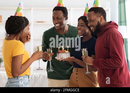 Cute black friends making surprise for birthday lady Stock Photo