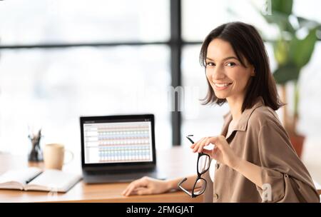 Happy young woman business analyst using laptop Stock Photo