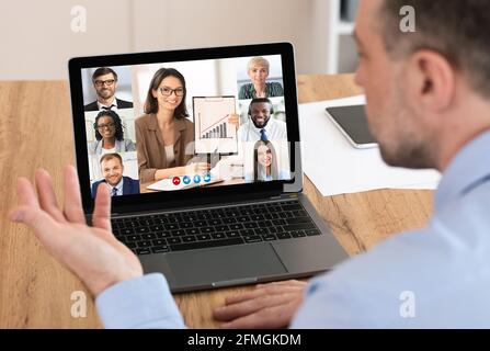 Businessman At Laptop Having Virtual Corporate Meeting Sitting In Office Stock Photo