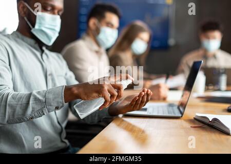 International workers wearing medical masks using sanitizer Stock Photo