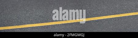 Panorama of asphalt texture with a long yellow line. Stock Photo