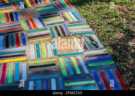 Top view on pieces of multicolored ceramic tiles decorated in garden. Old pavement of tiles textured. Street mosaic cobblestone sidewalk. Abstract,bac Stock Photo
