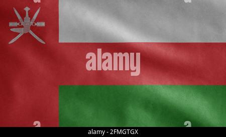 Omani flag waving in the wind. Close up of Oman banner blowing, soft and smooth silk. Cloth fabric texture ensign background. Use it for national day Stock Photo