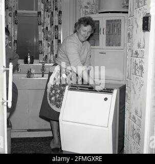 Doing the laundry in the 1960s. A lady is using a washboard to clean the  dirty laundry. The tool was designed for hand washing clothing rubbing them  agains the series of ridges