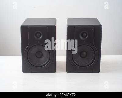 Black Pro Studio Speakers against a White and Gray Surface Stock Photo