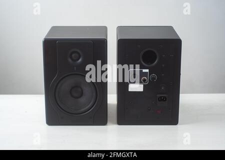 Double-Sided Black Pro Studio Speakers against a White and Gray Surface Stock Photo