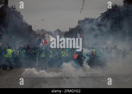 Protesters clash with police at the Champs-Elysees Avenue near the Arc de Triomphe during the fourth Saturday of national protests by the 'yellow vest Stock Photo
