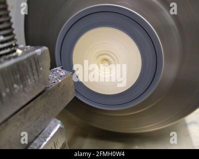 The lathe machine cutting the plastic rod. The manual lathe machine with the plastic bar. The abstract scene. Lathe grinding machine metalworking Stock Photo