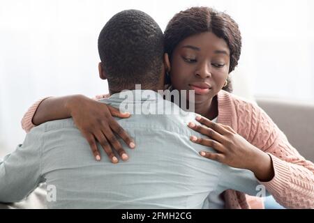 Dishonest black lady hugging her boyfriend or husband Stock Photo