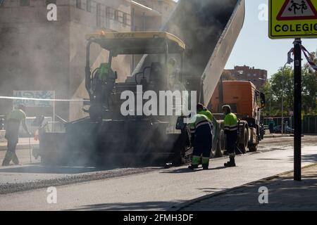 Madrid, Spain - May 5, 2021: Maintenance, rehabilitation and paving of streets in the downtown area of Madrid, Retiro district, using asphalt finisher Stock Photo