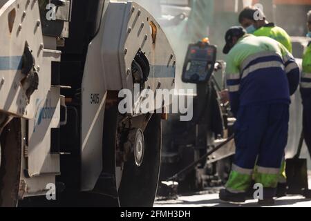 Madrid, Spain - May 5, 2021: Maintenance, rehabilitation and paving of streets in the downtown area of Madrid, Retiro district, using asphalt finisher Stock Photo