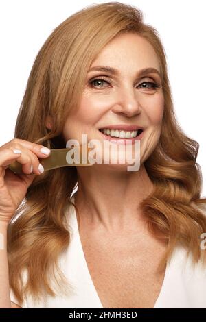 Portrait of a beautiful elderly woman in a white shirt with classic makeup and blond hair. Stock Photo