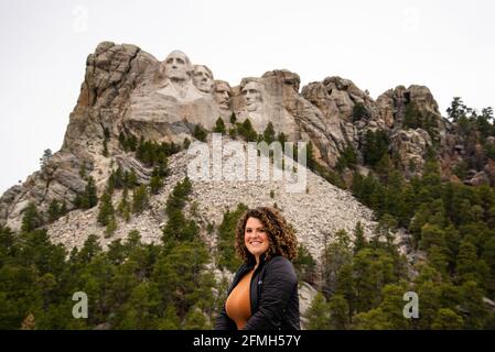 Keystone, South Dakota - April 25, 2021: Young woman standing in front of Mount Rushmore National Monument Black Hills South Dakota, president faces c Stock Photo
