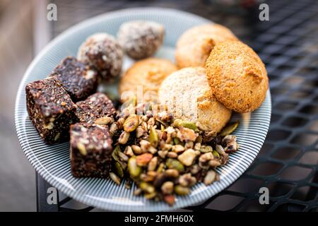 Flat top above closeup view of cookies on plate stack pile with raisin oatmeal vegan oat ingredient on wooden table Stock Photo