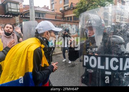 A person with the Colombian flag speaks with an agent of the mobile anti-riot squad Stock Photo