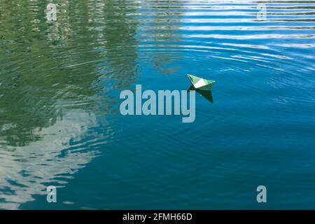 White paper skiffs float on water. Origami Stock Photo - Alamy