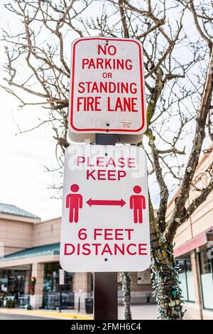 Fairfax County, Virginia strip mall with social distancing sign and no parking or standing fire lane closeup of text in winter with holiday decoration Stock Photo