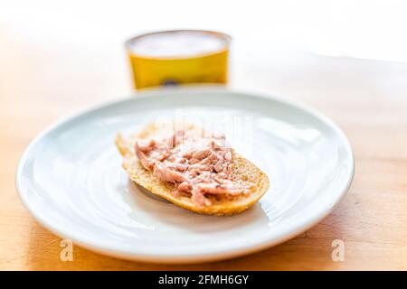 Canned cod liver in oil closeup macro of spread fish on toast bread plate on table with background of can as healthy omega 3 rich food popular in Russ Stock Photo