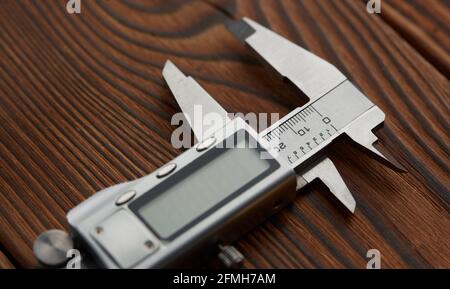 Electronic vernier caliper, wooden background Stock Photo