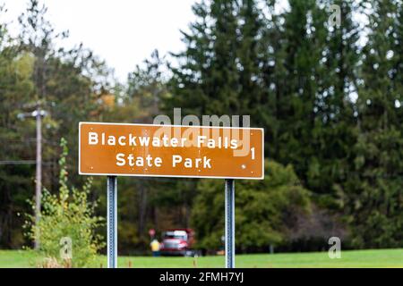 Davis, West Virginia and sign on road for Blackwater Falls one mile left on street in Canaan valley area in fall autumn season with trees in bokeh bac Stock Photo
