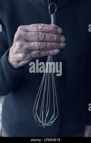 close-up of older womans hands holding an old whisk Stock Photo